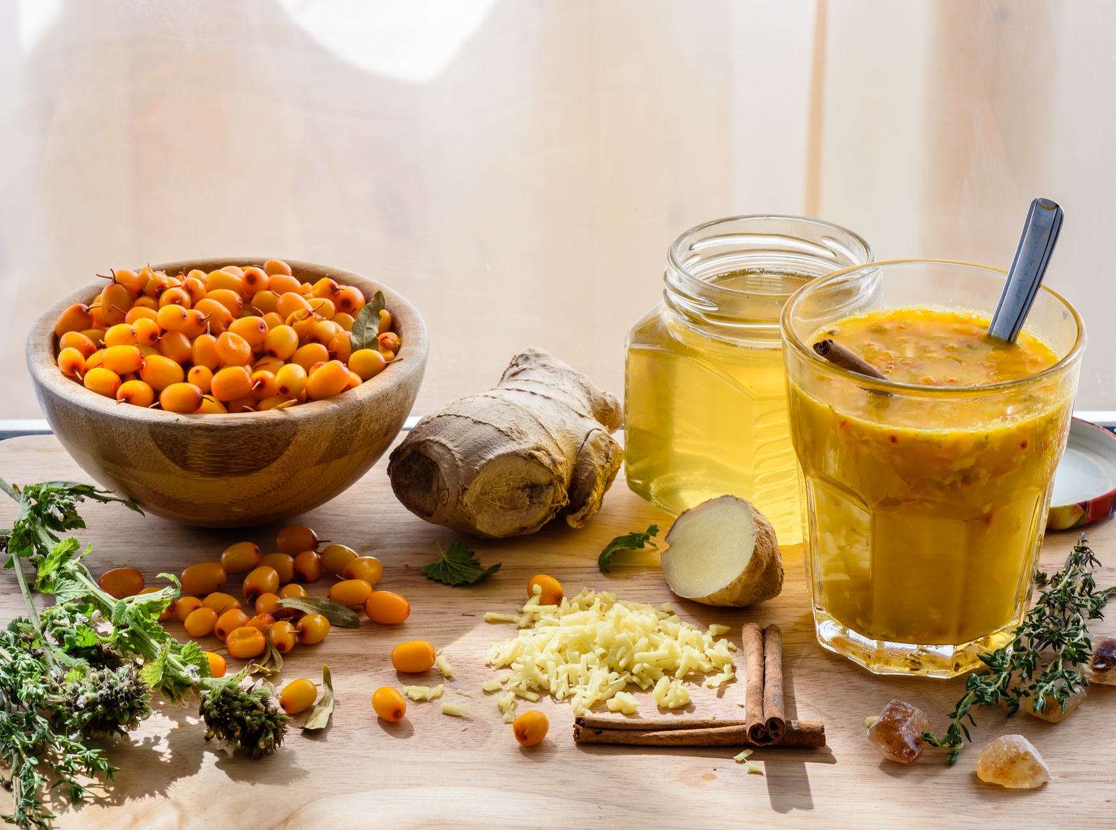 A bowl of sea buckthorn and ginger with a jar of liquid.